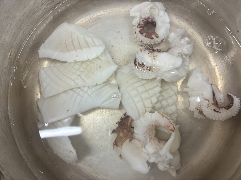 沸騰したお湯にイカをサッと(約3〜5秒)くぐらせている様子